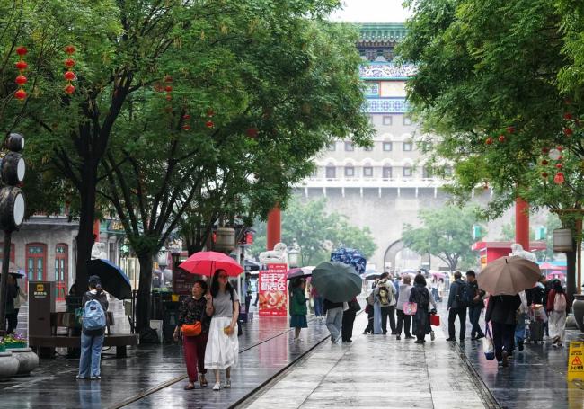 游客雨中游中轴 雨雾古都别样景